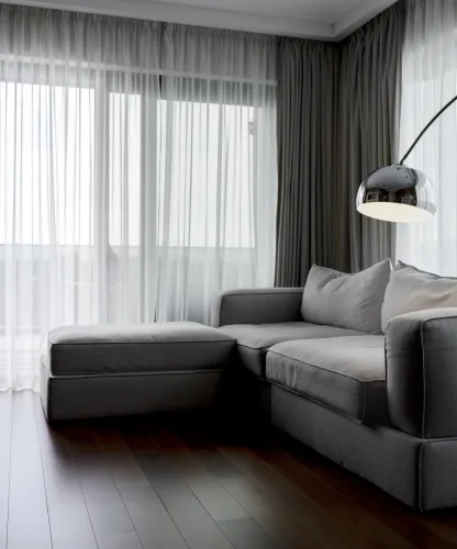 Sala sofisticada com cortinas em tons neutros e tecido leve proporcionando conforto, elegância e controle de luz