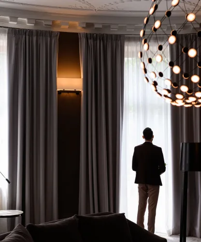 Ambiente sofisticado com cortinas de alto padrão em tons neutros valorizando a iluminação e a decoração moderna